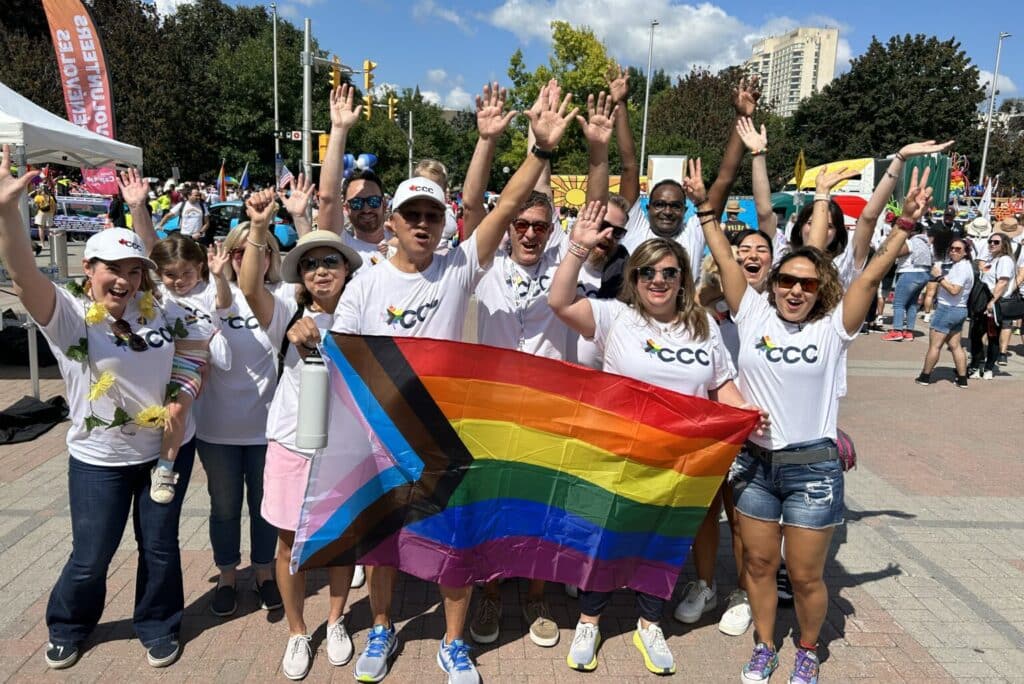 Group of people holding up a rainbow flag